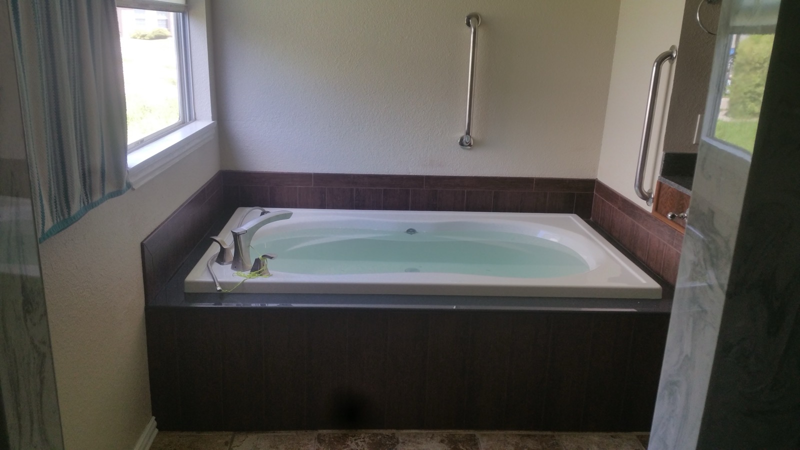 Jetted garden tub with a dark wood surround