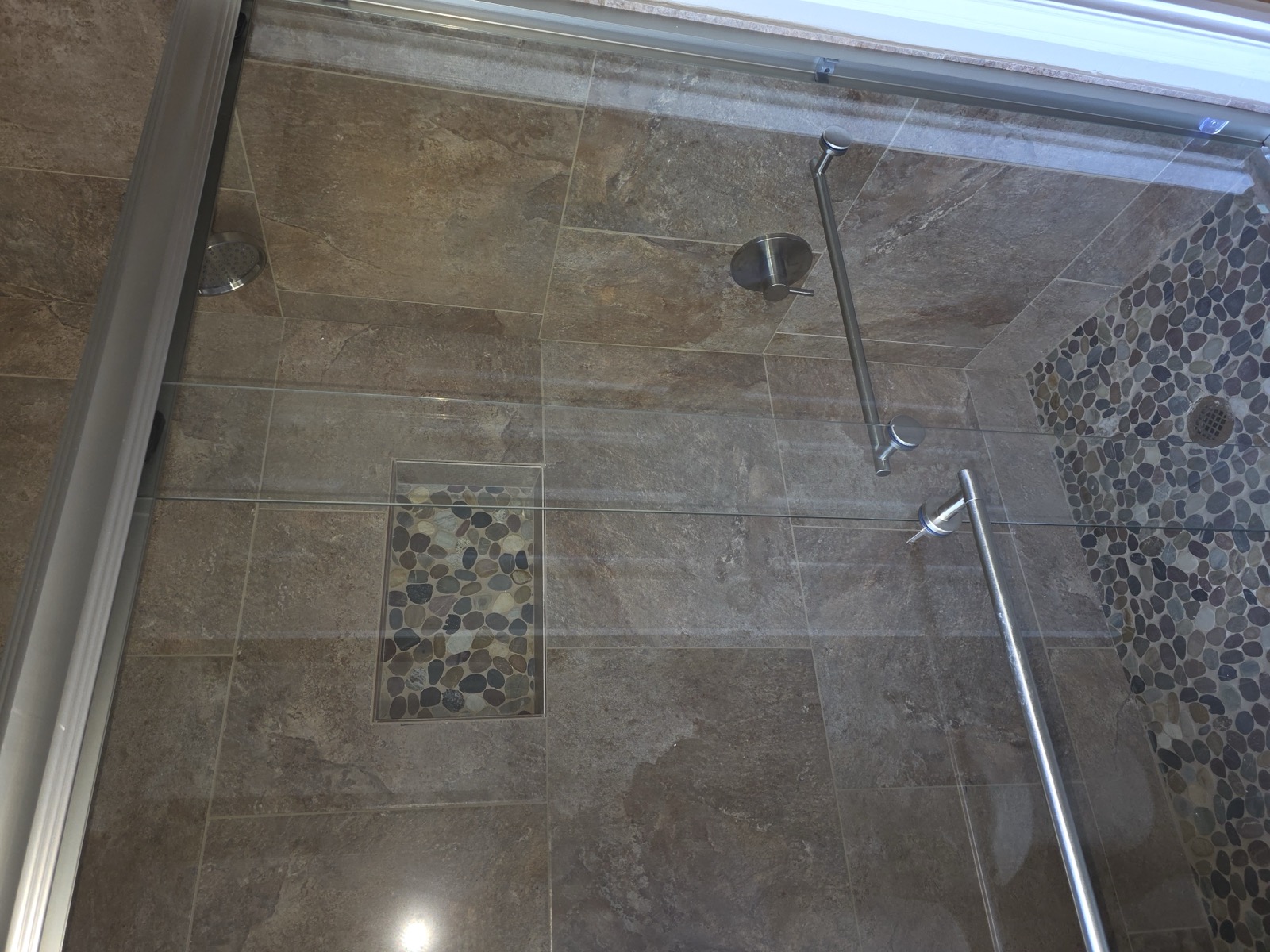 Finished slate tile walk-in shower with glass doors