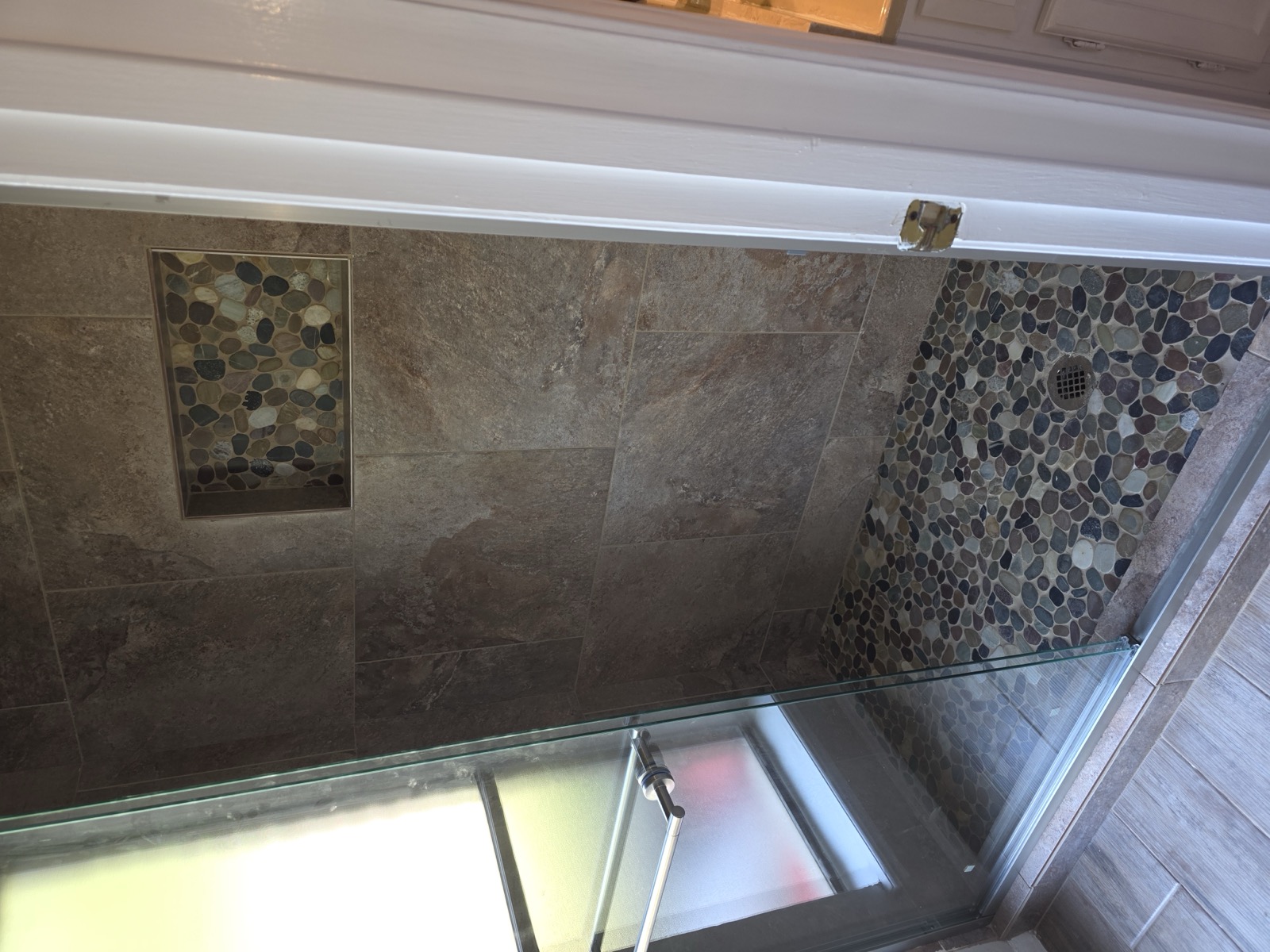 Slate walk-in shower with a river-pebble floor