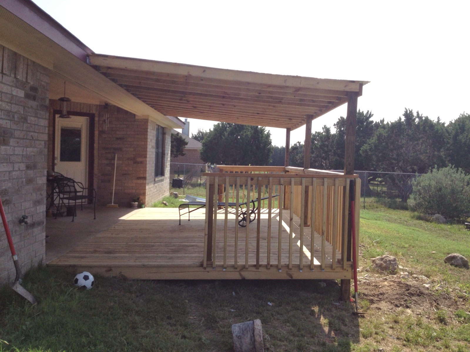 Pine pergola frame going up on a brick home